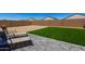 A well-maintained backyard with artificial turf, brick-style pavers, and chairs, designed for minimal upkeep and year-round enjoyment at 5146 E Diatomite Dr, San Tan Valley, AZ 85143
