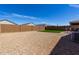 A low-maintenance backyard featuring gravel, artificial lawn, and patio set against a clear blue sky at 5146 E Diatomite Dr, San Tan Valley, AZ 85143