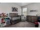 This Bedroom features a gray crib, changing table, a bookshelf and comfortable armchair for a peaceful and organized space at 5146 E Diatomite Dr, San Tan Valley, AZ 85143
