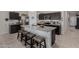 Kitchen island with granite countertops, dark cabinets, and seating for four at 5146 E Diatomite Dr, San Tan Valley, AZ 85143