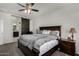 Main bedroom features a large bed, dark wood furniture, and a sliding barn door to the en suite at 5146 E Diatomite Dr, San Tan Valley, AZ 85143