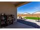 The covered patio features patio furniture and decor, overlooking an artificial grass yard, ideal for outdoor relaxation and entertainment at 5146 E Diatomite Dr, San Tan Valley, AZ 85143