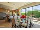 Bright dining area with a glass table, comfortable seating, and views of the outdoor landscape at 5434 E Lincoln Dr # 58, Paradise Valley, AZ 85253