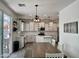 Open kitchen with white cabinets, stainless steel appliances, and farmhouse-style dining table at 5549 S Dillon --, Mesa, AZ 85212