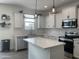 Well-lit kitchen features white cabinets, stainless appliances, subway tile backsplash and center island at 5549 S Dillon --, Mesa, AZ 85212