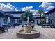 Outdoor seating area with umbrella-covered tables, surrounded by a fountain and charming landscaping at 5549 S Dillon --, Mesa, AZ 85212