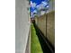 Long, narrow side yard with artificial turf, privacy walls, and a glimpse of blue sky at 5549 S Dillon --, Mesa, AZ 85212