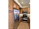 Modern kitchen with stainless steel refrigerator, electric range, microwave, and wood-look floors at 5640 E Bell Rd # 1098, Scottsdale, AZ 85254