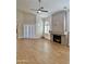 Bright living room features wood floors, arched windows, a ceiling fan, and a stone fireplace at 5640 E Bell Rd # 1098, Scottsdale, AZ 85254