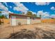Exterior view of backyard with a simple tan house, two white doors, and a wood fence at 6231 S 2Nd Ave, Phoenix, AZ 85041