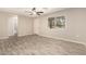 Bright living room features wood-look tile flooring, ceiling fan, and access to the bathroom at 6231 S 2Nd Ave, Phoenix, AZ 85041