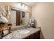 A decorated sink with a bronze countertop and a beautiful mirror is the center of this bathroom at 6244 W Clouse Dr, Phoenix, AZ 85033