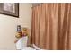 The powder room is equipped with decor, a towel, and a shower curtain at 6244 W Clouse Dr, Phoenix, AZ 85033