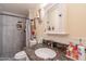 Modern bathroom features gray tiled shower, marble countertop, and decorative accents at 6244 W Clouse Dr, Phoenix, AZ 85033