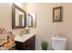 Charming powder room featuring decorative mirror, stylish vanity, and neutral decor at 6244 W Clouse Dr, Phoenix, AZ 85033