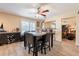 Bright dining area with wood-look tile, ceiling fan, and bar area adjacent to the living room at 6244 W Clouse Dr, Phoenix, AZ 85033