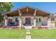 Inviting covered front porch adorned with colorful flowers, potted plants, and comfortable seating area at 6244 W Clouse Dr, Phoenix, AZ 85033