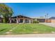 Charming single-story home boasting a lush green lawn, inviting covered porch, and convenient two-car garage at 6244 W Clouse Dr, Phoenix, AZ 85033
