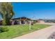 Charming single-story home featuring a well-manicured lawn and inviting porch with flowers and a table set at 6244 W Clouse Dr, Phoenix, AZ 85033