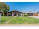 Charming single-story home boasting a lush green lawn, inviting covered porch, and convenient two-car garage at 6244 W Clouse Dr, Phoenix, AZ 85033