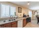 Kitchen features stainless steel sink, granite countertops, wood cabinets, and natural light at 6244 W Clouse Dr, Phoenix, AZ 85033