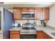 Updated kitchen features stainless steel appliances, granite countertops, and wood cabinets at 6244 W Clouse Dr, Phoenix, AZ 85033