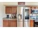 Bright kitchen with stainless steel refrigerator, granite countertops, and wooden cabinetry at 6244 W Clouse Dr, Phoenix, AZ 85033