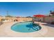 Inground pool with red umbrellas, outdoor grilling station, and lounge chairs in the backyard at 6244 W Clouse Dr, Phoenix, AZ 85033