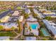 Aerial view of a community pool and building within a sprawling well maintained community with tree lined street at 6556 N 43Rd Ave, Glendale, AZ 85301