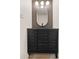 Modern bathroom vanity with dark wood details, a black faucet and unique mirror at 6556 N 43Rd Ave, Glendale, AZ 85301