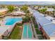 Aerial view of the community pool with a sunbathing area, lush green landscaping and shuffleboard court at 6556 N 43Rd Ave, Glendale, AZ 85301