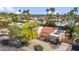Overhead view of home surrounded by palm trees, showcasing landscaping, a tile roof, and solar panels at 6611 E Voltaire Ave, Scottsdale, AZ 85254