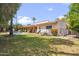 Backyard featuring a pool, well-manicured grass, and mature trees at 6611 E Voltaire Ave, Scottsdale, AZ 85254