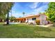 Large, grassy backyard featuring a covered patio and swimming pool at 6611 E Voltaire Ave, Scottsdale, AZ 85254