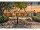 Charming home exterior featuring a tiled roof portico, desert landscaping, and two-car garage at 6611 E Voltaire Ave, Scottsdale, AZ 85254