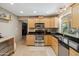 Well-lit kitchen with wood cabinets, granite countertops, stainless steel appliances, and tile flooring at 6611 E Voltaire Ave, Scottsdale, AZ 85254