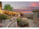 Backyard view with a covered patio featuring brickwork and manicured gardens, with cafe string lights at 7423 E Cambridge Ave, Scottsdale, AZ 85257