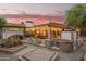 Exterior view of the covered backyard patio featuring outdoor kitchen area with floral landscaping at sunset at 7423 E Cambridge Ave, Scottsdale, AZ 85257