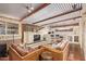 Spacious basement Gathering room featuring white brick fireplace, wet bar, wood ceiling beams and floors at 7423 E Cambridge Ave, Scottsdale, AZ 85257