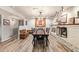 Bright dining room with updated lighting, wood laminate floors, and white brick fireplace at 7423 E Cambridge Ave, Scottsdale, AZ 85257