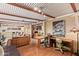 Spacious living room with brick fireplace, wooden floors, leather couches, and a large work space at 7423 E Cambridge Ave, Scottsdale, AZ 85257