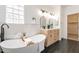 Stylish bathroom with soaking tub, double vanities, modern fixtures, and herringbone floor at 7516 W Mary Jane Ln, Peoria, AZ 85382