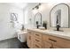 Elegant bathroom featuring a soaking tub, double vanity with modern fixtures, and stylish herringbone flooring at 7516 W Mary Jane Ln, Peoria, AZ 85382