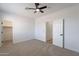 A bright bedroom features neutral carpet, a ceiling fan, and ample closet space for comfortable living at 7516 W Mary Jane Ln, Peoria, AZ 85382