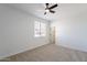 Bright bedroom with ceiling fan, window with blinds, and door, providing a calm and inviting space at 7516 W Mary Jane Ln, Peoria, AZ 85382