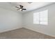 Light-filled bedroom with ceiling fan, window with blinds, offering a bright and welcoming atmosphere at 7516 W Mary Jane Ln, Peoria, AZ 85382