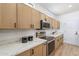 Modern kitchen with stainless steel appliances, light wood cabinets, quartz countertops and natural light, ideal for cooking at 7516 W Mary Jane Ln, Peoria, AZ 85382
