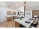 Bright kitchen featuring a large island with quartz countertops, modern lighting, and seamless flow to living spaces at 7516 W Mary Jane Ln, Peoria, AZ 85382