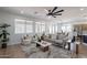 Stylish living room with hardwood flooring, a contemporary ceiling fan, and large windows at 7516 W Mary Jane Ln, Peoria, AZ 85382