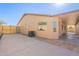 The rear of the home has a covered patio, AC unit, stone accents, and a low-maintenance desert-landscaped yard at 7516 W Mary Jane Ln, Peoria, AZ 85382